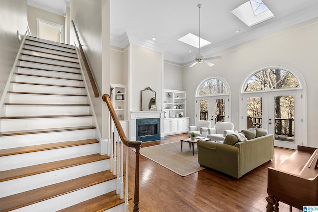 living room featuring ceiling fan, a skylight, a wealth of natural light, and french doors