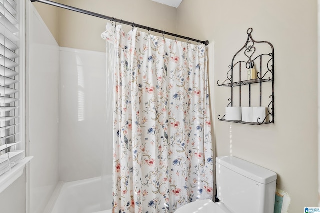 bathroom featuring shower / bath combination with curtain and toilet