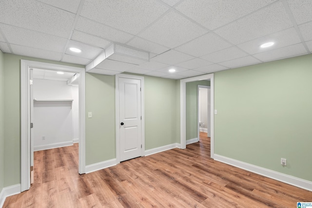 basement featuring a drop ceiling and wood-type flooring