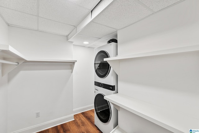 laundry room with dark hardwood / wood-style flooring and stacked washer / drying machine