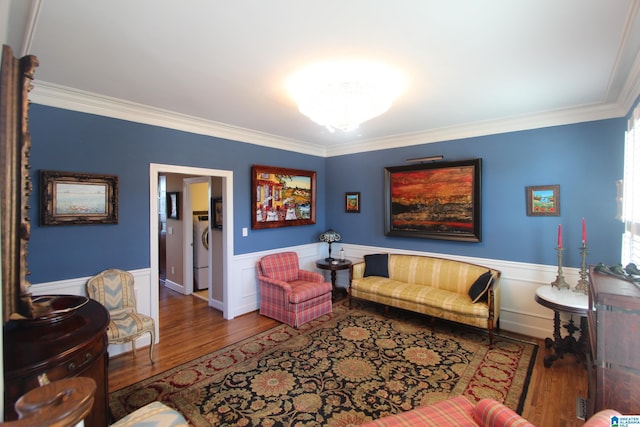 living room with hardwood / wood-style floors, washer / clothes dryer, and crown molding