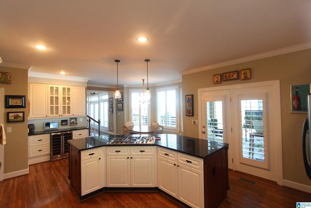 kitchen featuring wine cooler, crown molding, white cabinets, and pendant lighting