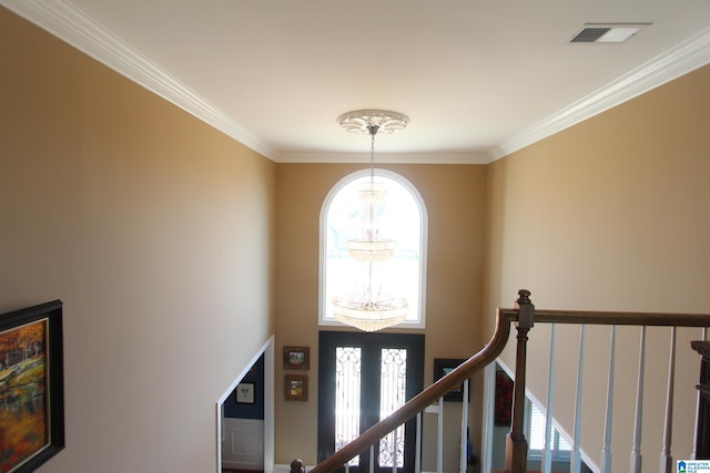 staircase featuring a notable chandelier and crown molding