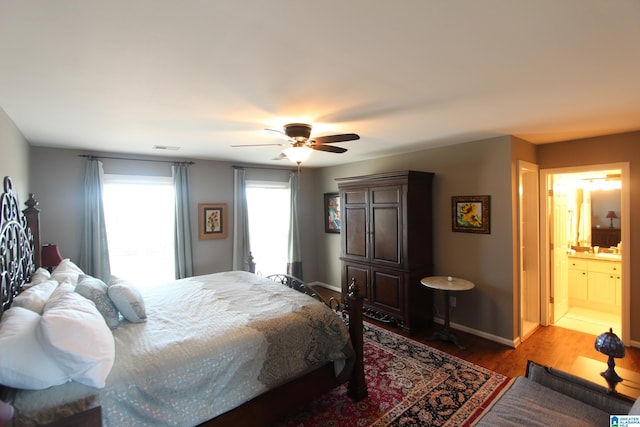 bedroom featuring connected bathroom, light hardwood / wood-style flooring, and ceiling fan