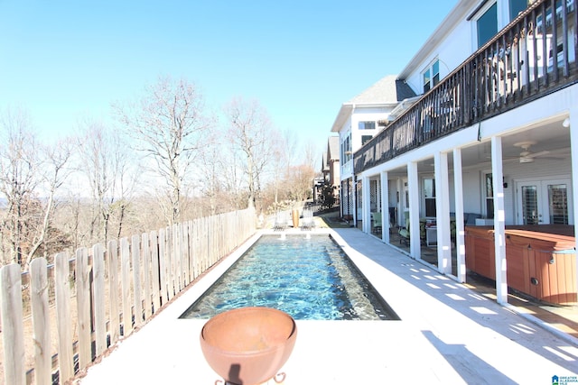 view of swimming pool with ceiling fan and a hot tub