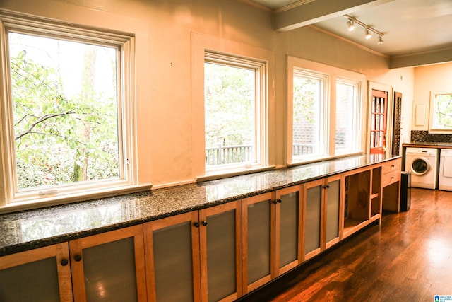 interior space with dark hardwood / wood-style floors, a healthy amount of sunlight, and washer / clothes dryer