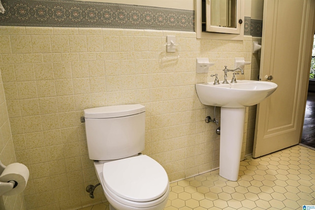 bathroom featuring tile patterned flooring, tile walls, and toilet