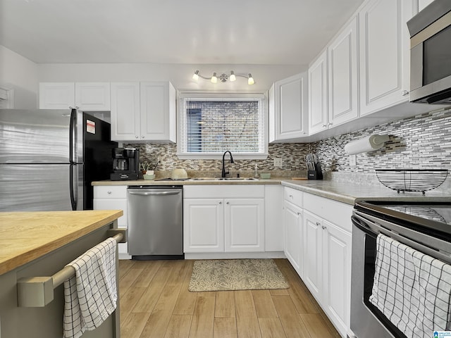 kitchen featuring decorative backsplash, sink, white cabinetry, and stainless steel appliances