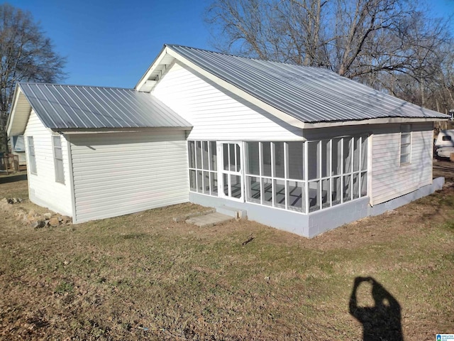 back of property with a yard and a sunroom