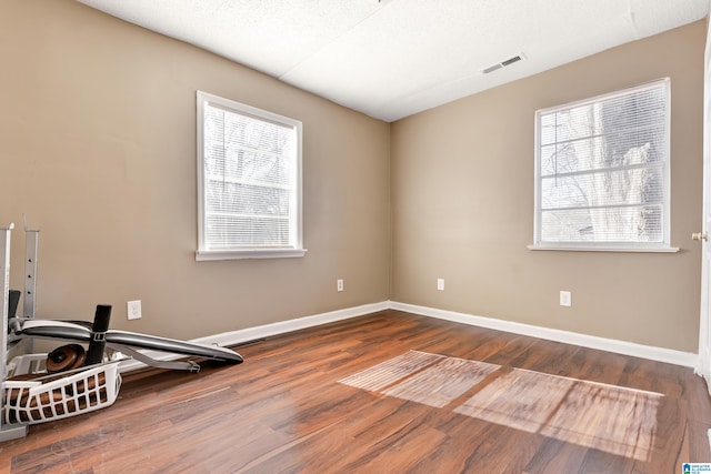 exercise room featuring plenty of natural light and hardwood / wood-style floors