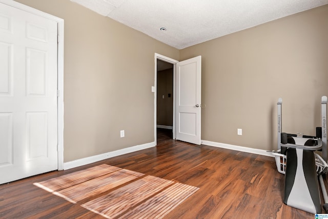 interior space featuring a textured ceiling and dark hardwood / wood-style flooring