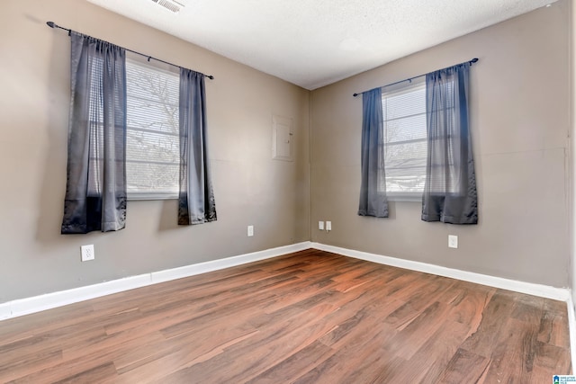 spare room with hardwood / wood-style flooring and a textured ceiling