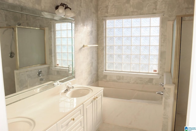 bathroom featuring independent shower and bath, a wealth of natural light, and vanity