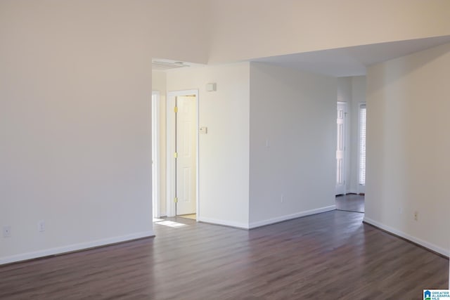 empty room with dark hardwood / wood-style flooring