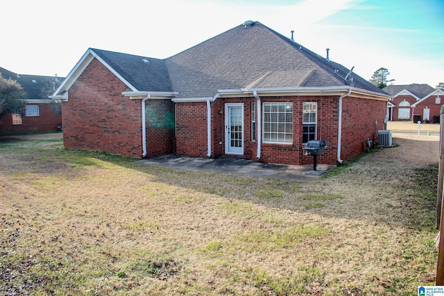 rear view of house with a lawn, central air condition unit, and a patio area