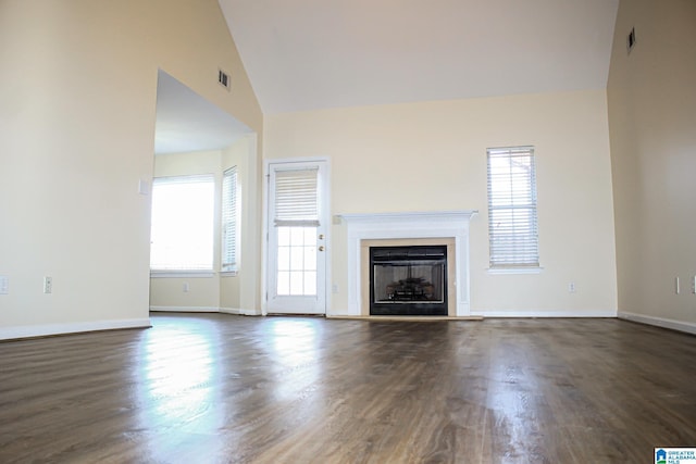 unfurnished living room with high vaulted ceiling and dark hardwood / wood-style floors