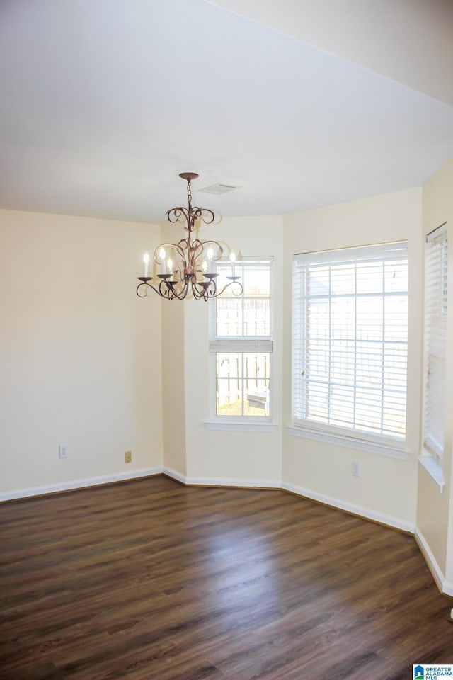 unfurnished room featuring dark wood-type flooring and a chandelier