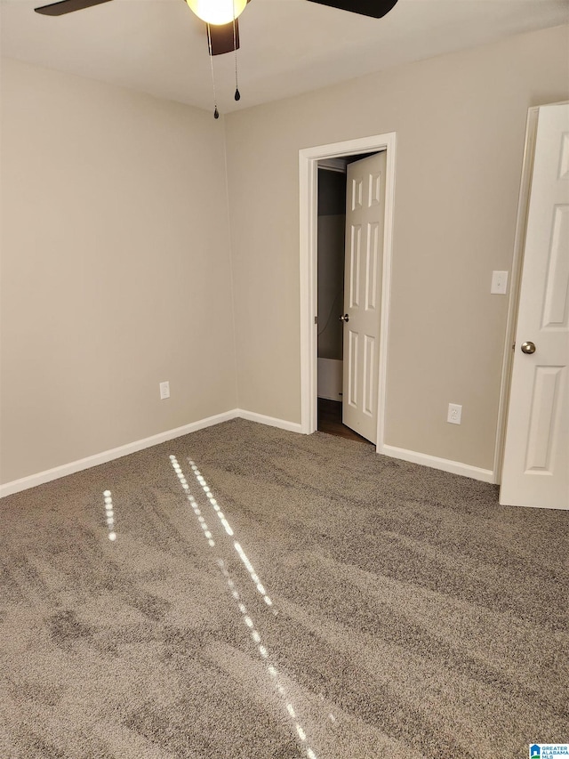 unfurnished bedroom with ceiling fan and dark carpet