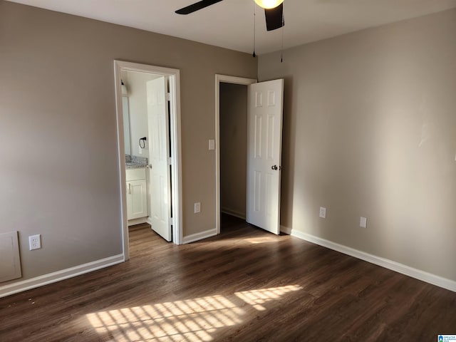 unfurnished bedroom featuring ceiling fan, ensuite bath, and dark hardwood / wood-style floors