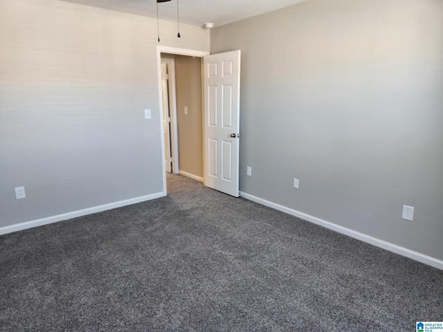 spare room featuring dark carpet