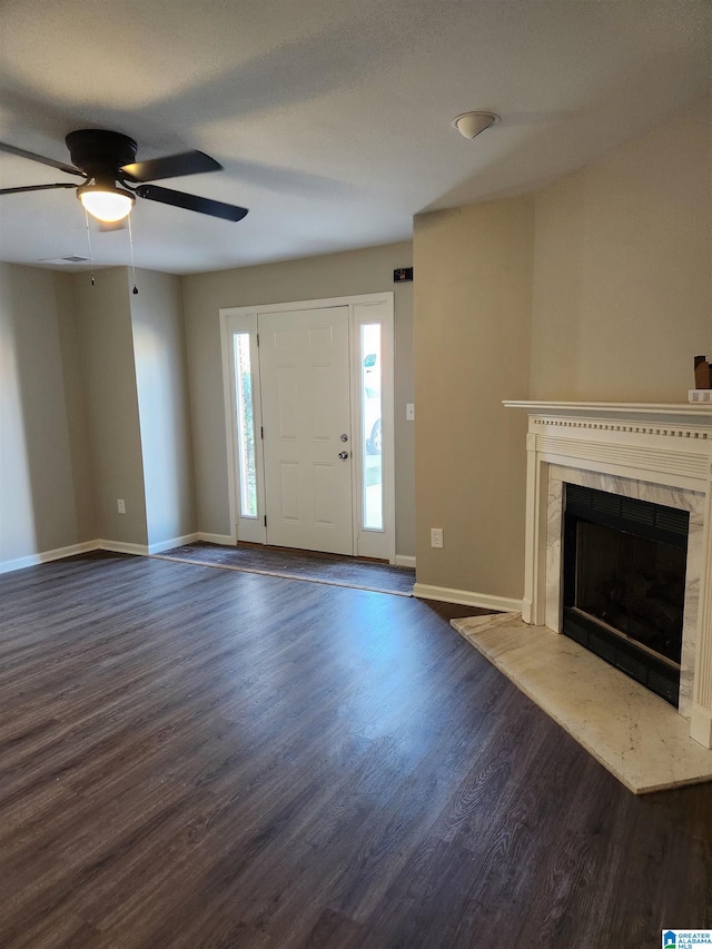 entrance foyer featuring ceiling fan, a high end fireplace, and dark hardwood / wood-style floors