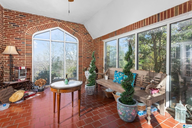 sunroom / solarium featuring a healthy amount of sunlight and lofted ceiling