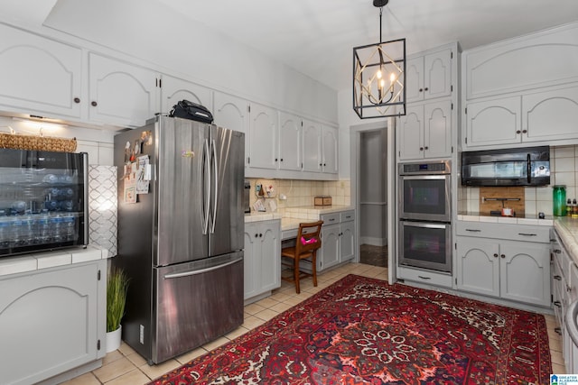 kitchen featuring white cabinets, stainless steel appliances, and hanging light fixtures