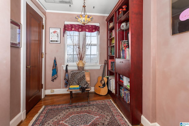 living area with dark hardwood / wood-style flooring and crown molding