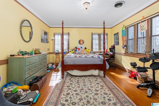 bedroom with wood-type flooring and ornamental molding