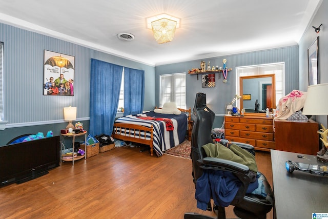 bedroom with wood-type flooring and crown molding