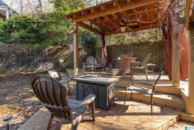 view of patio featuring ceiling fan, an outdoor fire pit, and a wooden deck