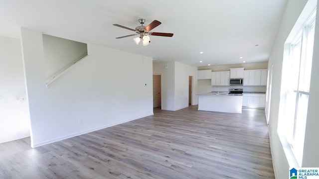 unfurnished living room featuring light hardwood / wood-style flooring and ceiling fan