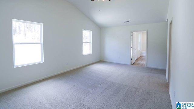 carpeted spare room featuring vaulted ceiling