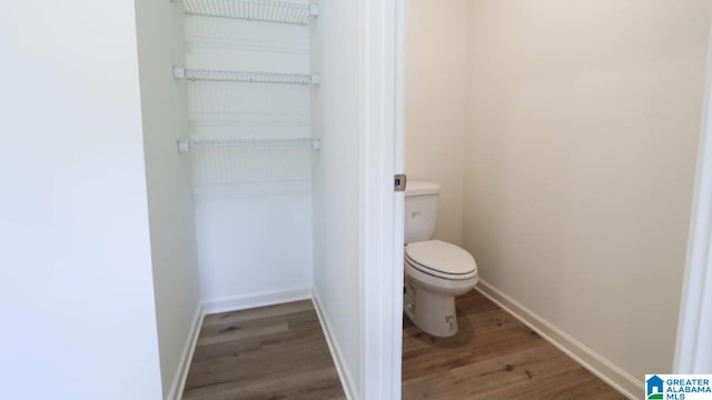 bathroom featuring hardwood / wood-style flooring and toilet