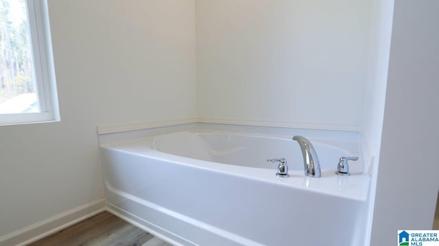 bathroom featuring a tub to relax in and hardwood / wood-style floors