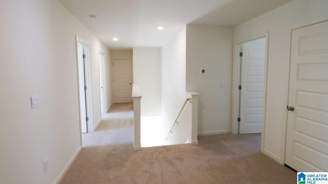 hall with light colored carpet