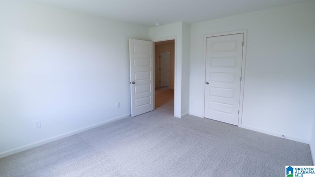 unfurnished bedroom featuring carpet flooring and a closet