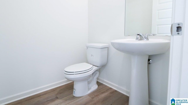 bathroom with hardwood / wood-style floors and toilet