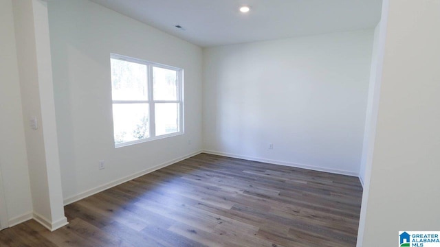 empty room with a healthy amount of sunlight and dark hardwood / wood-style flooring