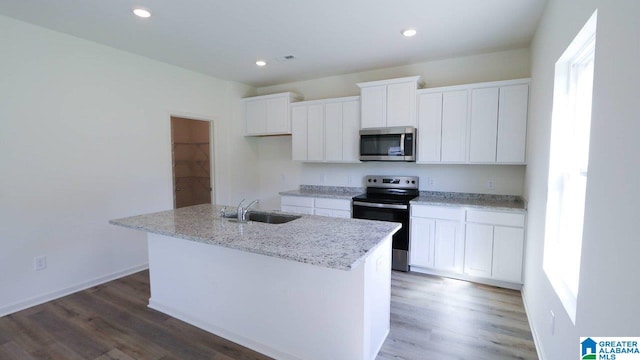 kitchen with sink, white cabinetry, stainless steel appliances, and a kitchen island with sink