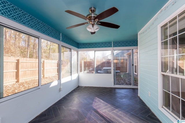 unfurnished sunroom with ceiling fan and a healthy amount of sunlight