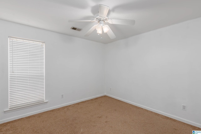 carpeted spare room featuring ceiling fan