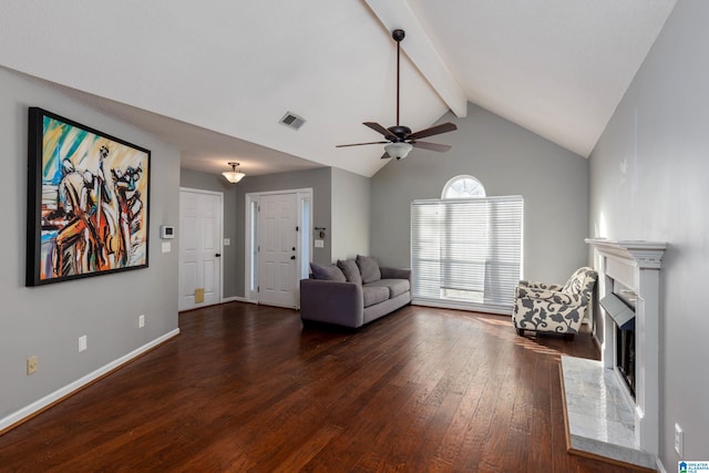 unfurnished living room with lofted ceiling with beams, a tiled fireplace, dark hardwood / wood-style floors, and ceiling fan