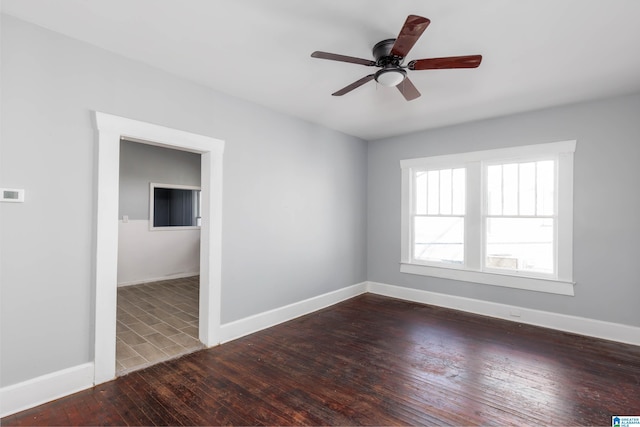 empty room with ceiling fan and dark hardwood / wood-style flooring