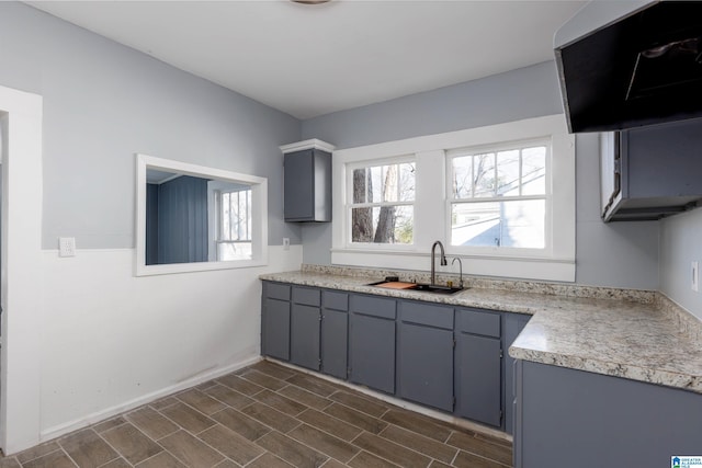 kitchen featuring gray cabinets, extractor fan, dark wood-type flooring, and sink