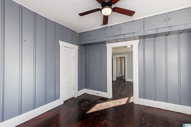 empty room featuring ceiling fan and dark wood-type flooring