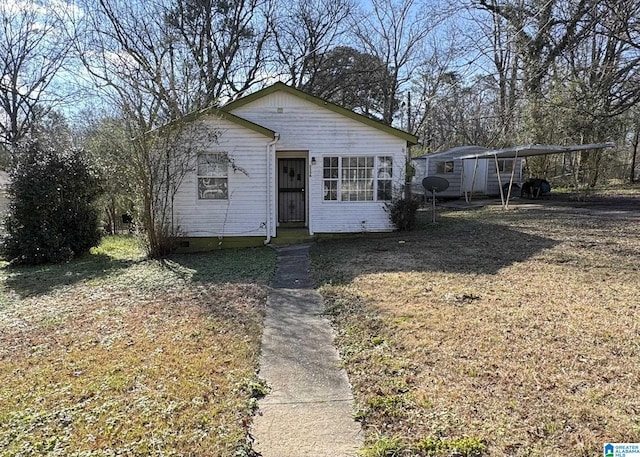 view of front facade featuring a front lawn and a carport