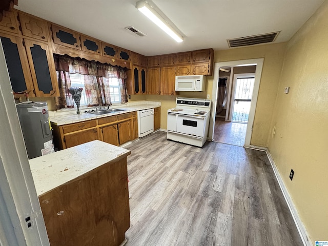 kitchen featuring a healthy amount of sunlight, white appliances, sink, and light hardwood / wood-style flooring