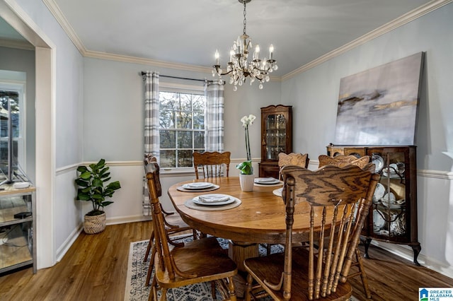 dining space featuring hardwood / wood-style floors, ornamental molding, and an inviting chandelier