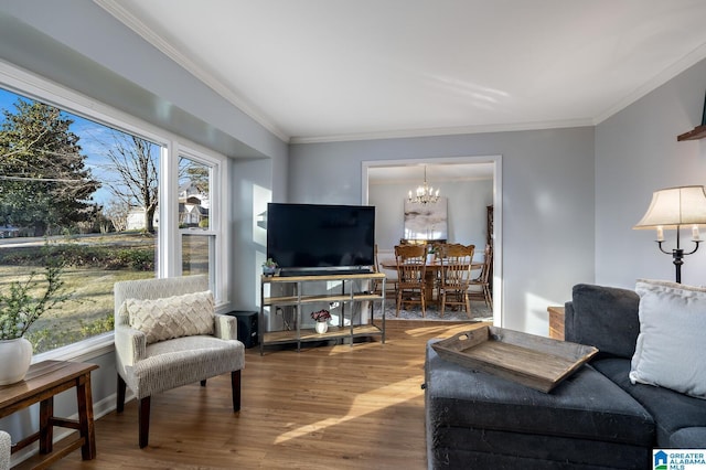 living room with wood-type flooring, ornamental molding, and a notable chandelier